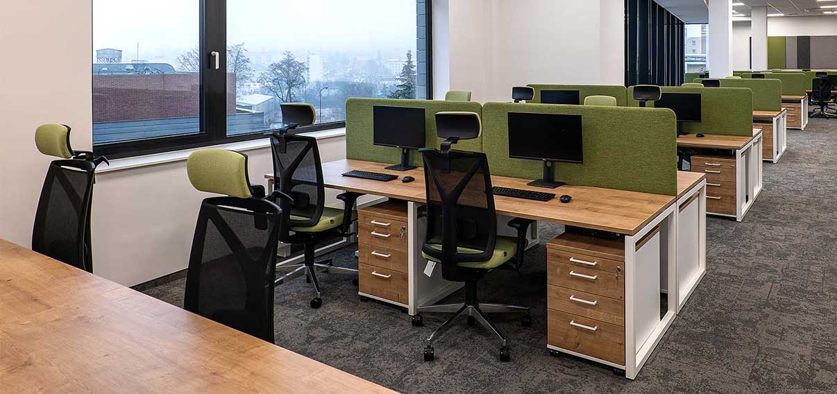 open office with wooden worktops and draws with green desk chairs - Narbutas image
