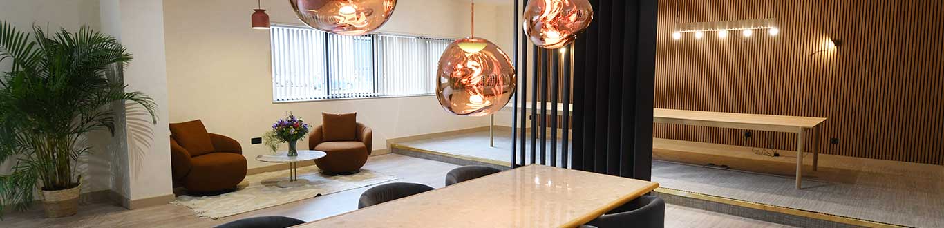 Modern office interior with hanging copper lamps and wooden accents.