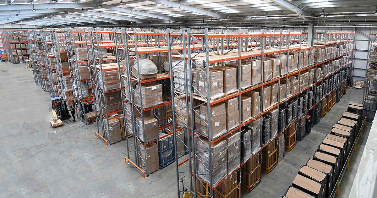 Extensive warehouse shelves stocked with boxes, industrial scale storage facility interior.