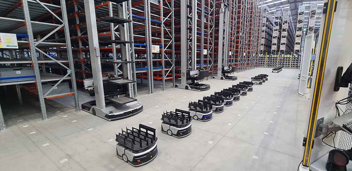  A fleet of autonomous robots lined up in a warehouse.